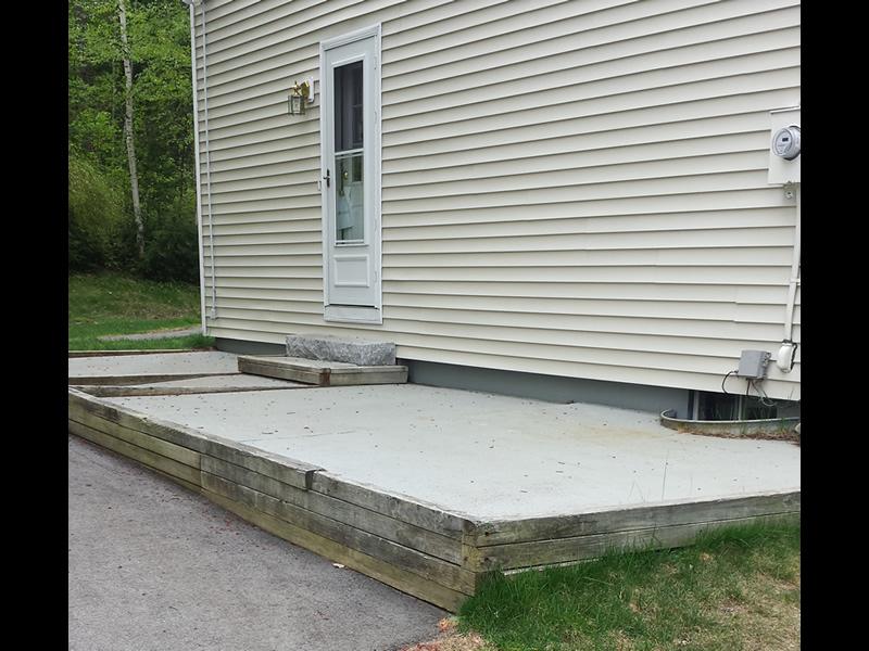 The old patio was worn out and had no railing to prevent someone from steping off, this is a code violation, and a safety hazard.